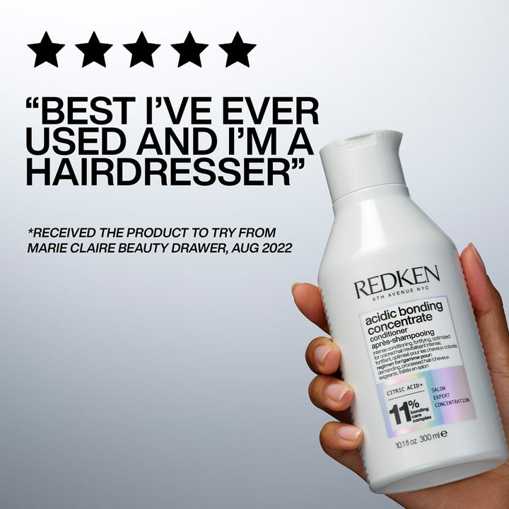 Hand holding Redken Acidic Bonding Concentrate Conditioner with five-star hairdresser review