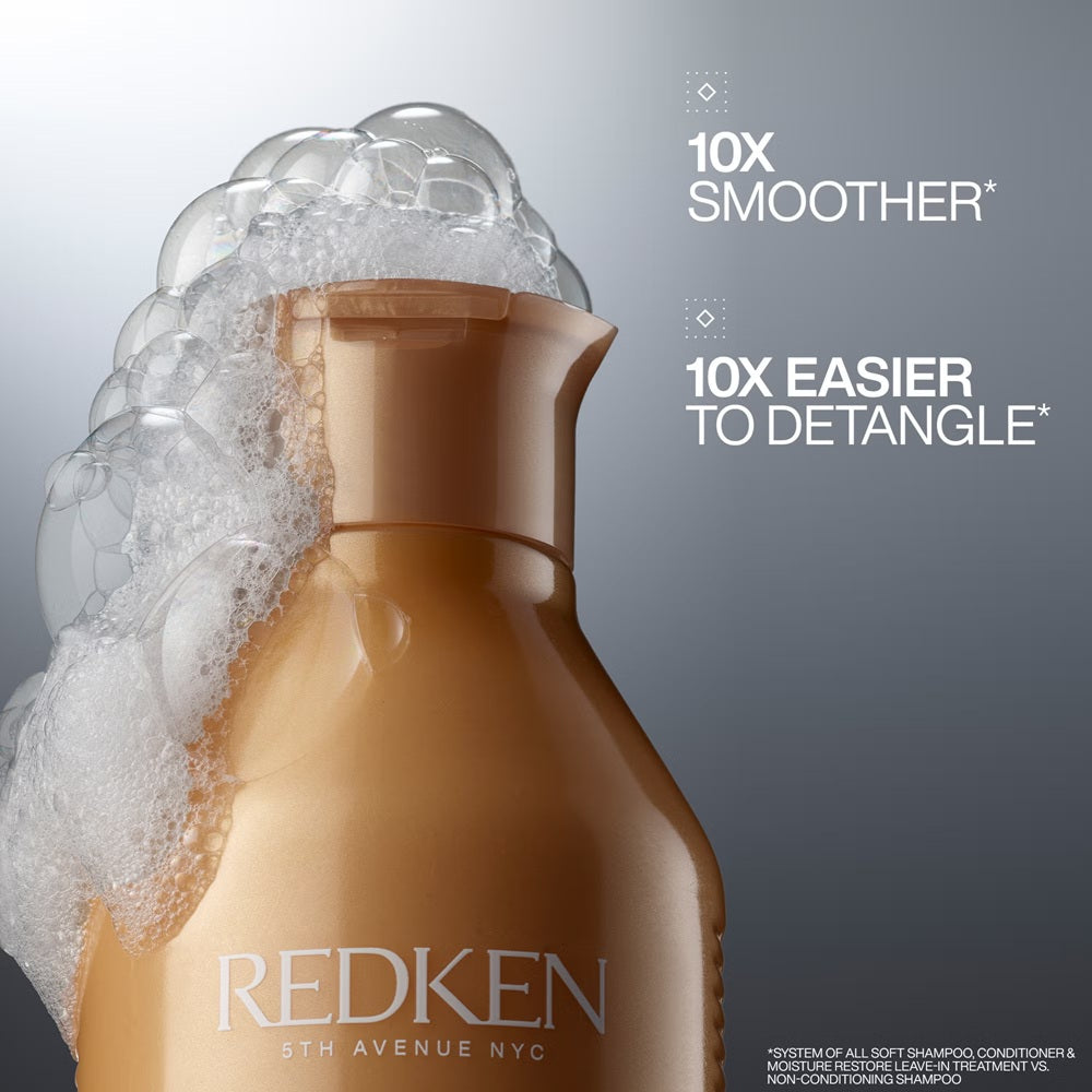 Redken All Soft Shampoo bottle surrounded by rich lather